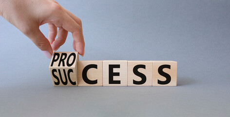 Process and Success symbol. Businessman Hand turns a cube and changes the word success to process. Beautiful grey background. Businessman hand. Business and process and success concept. Copy space