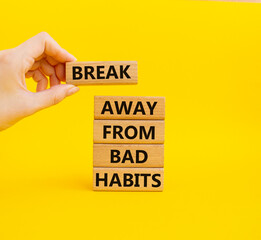 Break away from bad habits symbol. Wooden blocks with words Break away from bad habits. Beautiful yellow background. Businessman hand. Business and Break away from bad habits concept. Copy space.