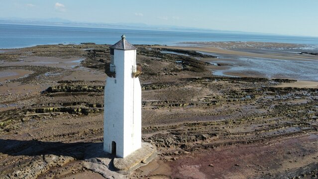 Aerial shot of the lighthouse at Southerness Village in Scotland overlooking the horizon