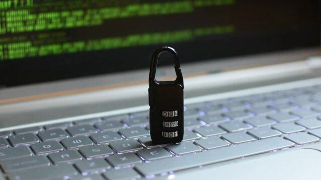 Locked padlock on top of laptop. A green digital pattern is seen on the background 