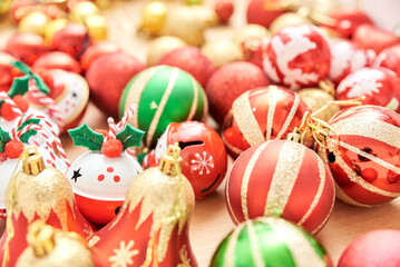 Fototapeta na wymiar Box of mixed Christmas tree ornaments, balls and bells in the classic traditional colors of red, green, white and gold.