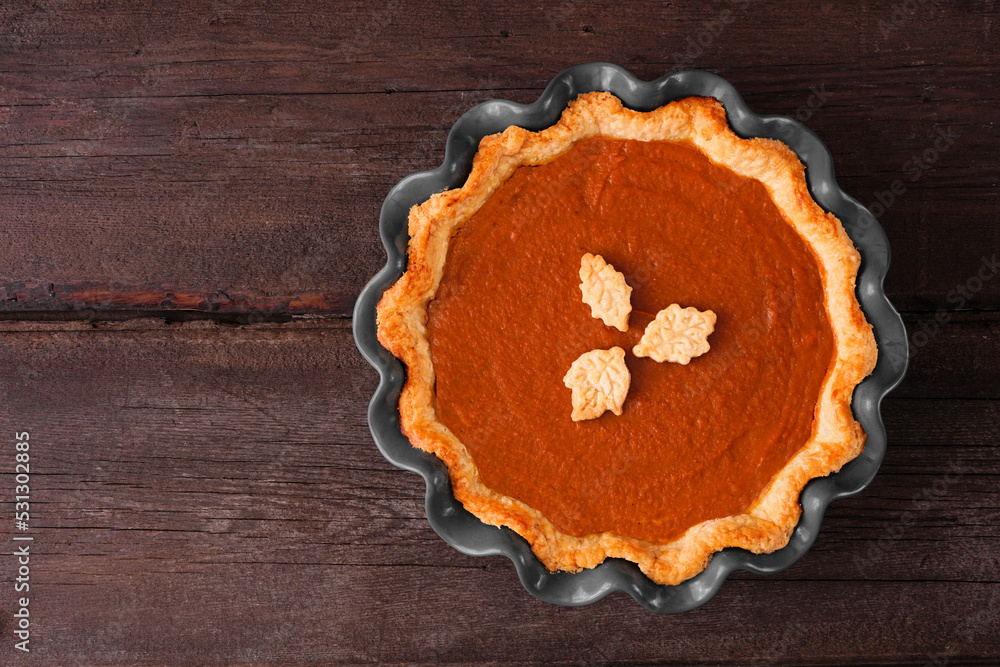 Aufkleber homemade fall pumpkin pie. top down view on a dark rustic wood background.