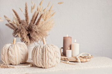Autumn table decoration. Interior decor for fall holidays with handmade pumpkins and candles....