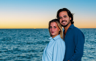 portraits of a beautiful couple with the ocean in the background