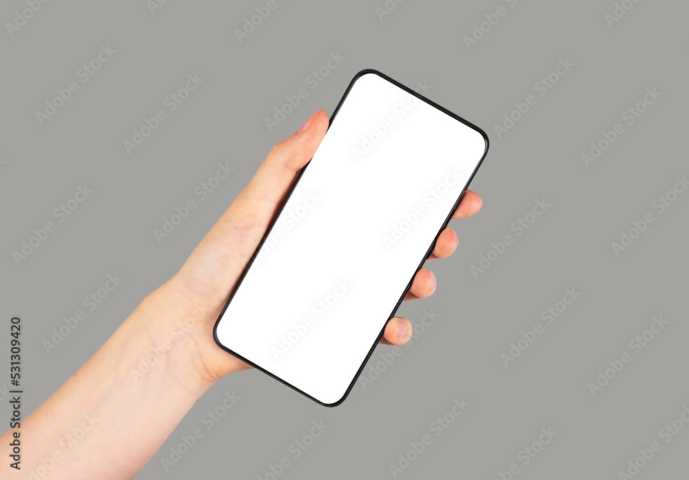 Poster hand holding phone mockup in angled position on grey background. smartphone template with empty scre