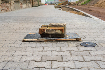 Old red bricks with cement, on a broken board, on the sidewalk