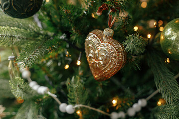 Christmas tree with vintage baubles and golden lights close up. Modern decorated christmas tree...