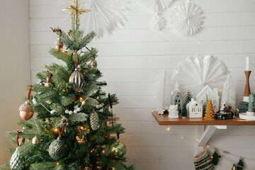 Christmas tree with vintage baubles and little christmas village decoration. Modern christmas tree...