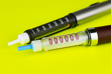 insulin pens on a green background. selective focus