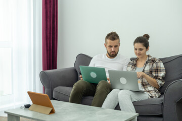 Couple at home doing online shopping with laptop