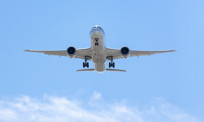 White airplane from bottom front ready to land, with the wheels off prepared. End of vacations concept.