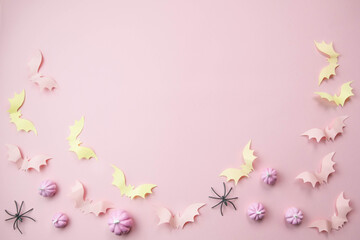 pink background with a place for text with small pink pumpkins with pink bats spiders skeletons broom witches, the concept of a creative happy Halloween