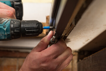 Installing a stainless hinge on an interior door, screwing in a screw is detailed in the plan.