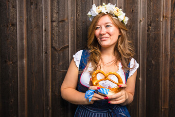 Beautiful woman with pretzel in a traditional bavarian dirndl Oktoberfest.