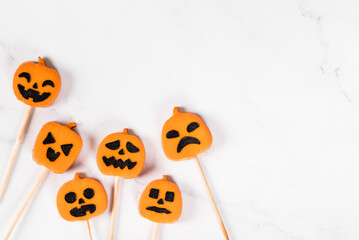 Themed Pumpkin jelly candies on a wooden stick. Halloween. Light background. Top view. Copy space
