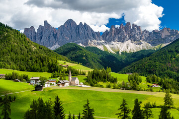 Saint Magdalena church of Villnöß (Funes) in South Tyrol in northern Italy with the iconic Gruppo delle Odle mountains of the Dolomite Alps in the background - obrazy, fototapety, plakaty