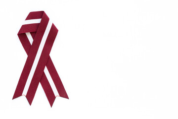 Ribbon in the colours of Latvian flag isolated on a white background.