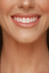 detail of a woman's smile with perfect white teeth and lips with lipstick
