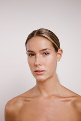 beauty portrait with bare shoulders of Caucasian woman looking at camera without makeup