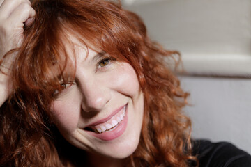 portrait of red haired woman looking at camera with big smile