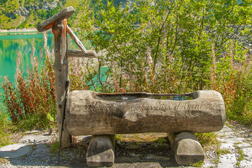 Wooden water fountain in the mountains of the alpine valleys