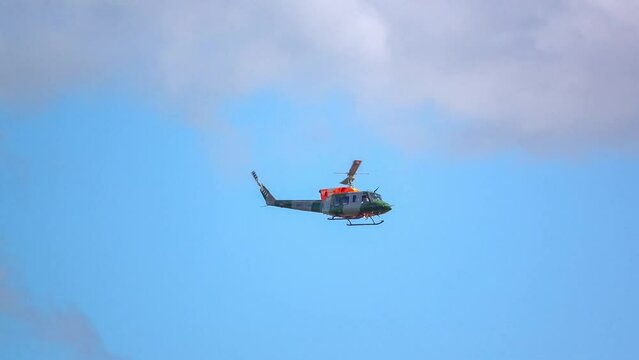 British Army Air Corps ZJ969 Bell 212 helicopter conducting pilot training and assessment, light cloud blue sky 