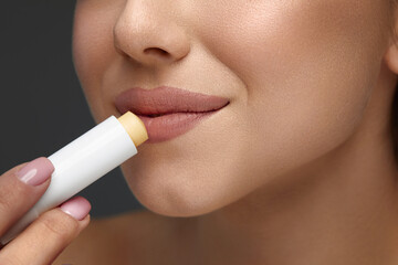 Lips Protection. Close up Beautiful Woman Lips Applying Lip Balm, Lipcare Stick On. Lips Skin Care Cosmetics Concept