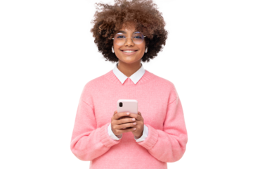 Smiling pretty african girl with afro hairstyle holding smartphone with both hands, looking at camera