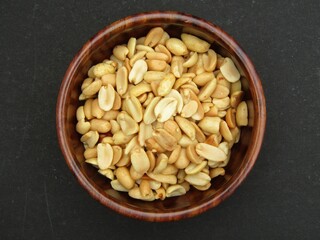 Indian snack food salted peanuts in a woode bowl 