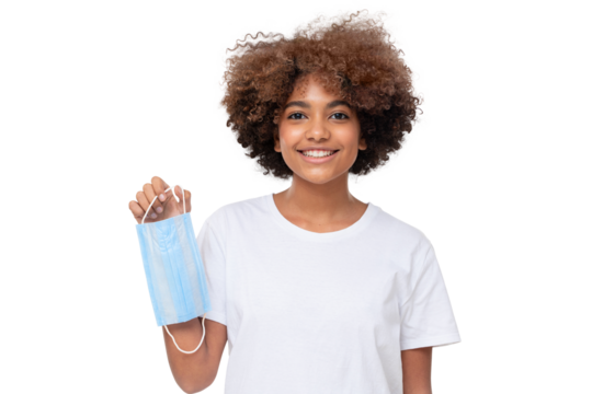 Smiling african school girl holding face mask after the end of pandemic. Coronavirus defeated, people are getting back to normal life