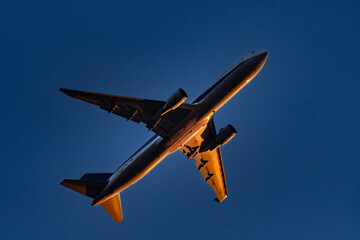 Fototapeta na wymiar 夕日を浴びて羽田空港を離陸したジェット定期旅客機