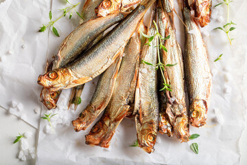 Fresh smoked sprats on white food paper.