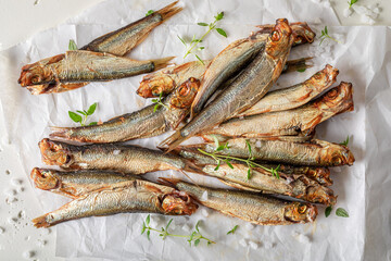Salty smoked sprats as appetizer by the sea.