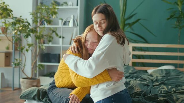 Help and Support. Red Haired Unhappy Depressed Teenager Girl Talks to Female Friend, Using Tissues, they Hug Sitting Together at Home. Teenage Psychological Trauma, Adolescence Concept. Mental Health