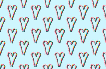 Pattern of hard candy cane heart on blue pastel background