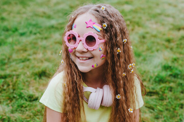 Cute teenage girl with stickers on her face wearing pink glasses