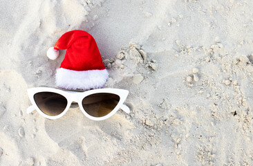 Christmas background Santa Claus hat on the beach with sunglases