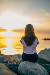 close-up portrait of a woman from the back at sunset on the sea, ocean on a trip