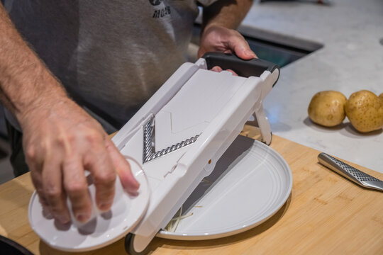 Mandolin Slicing Raw Potato In Home Kitchen.