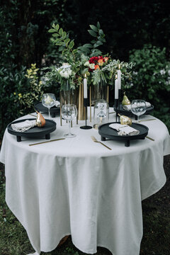 Modern wedding table decorated with plates, cutlery and flowers