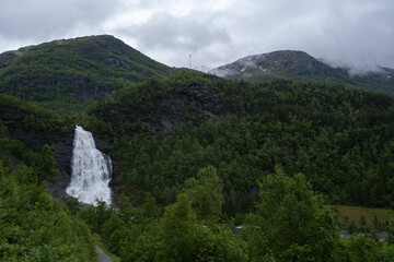 Wonderful landscapes in Norway. Hordaland. Beautiful scenery of  Fossen Bratte (Brattefossen) waterfall from the Eikedalselva river. Mountains, trees in background. Rainy day. Selective focus