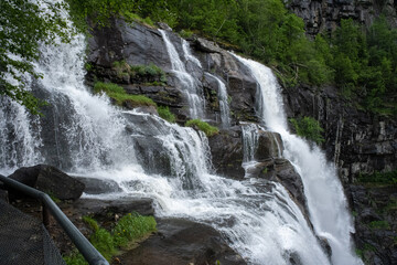 Wonderful landscapes in Norway. Hordaland. Beautiful scenery of Skjervsfossen waterfall from the Storelvi river on the Hardanger scenic route. Mountains, trees in background. Rainy day Selective focus