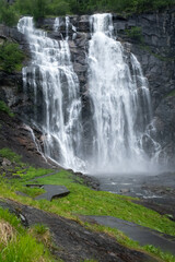 Wonderful landscapes in Norway. Hordaland. Beautiful scenery of Skjervsfossen waterfall from the Storelvi river on the Hardanger scenic route. Mountains, trees in background. Rainy day Selective focus