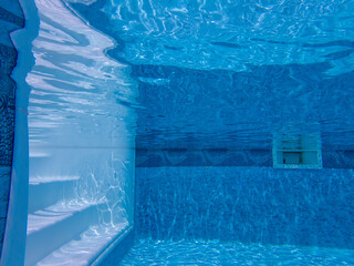 Underwater view of tranquil blue swimming pool with white steps