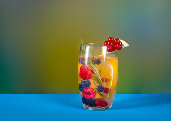 Drink with a slice of lemon, orange, red currant and berries