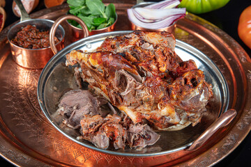 Roasting head of a lamb. Traditional Turkish Offal Food Kelle Sogus, Lamb Head Meat with Brain Served Portion served on a copper plate.