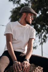 Hombre joven modelo con camisa blanca, gafas de sol y gorra