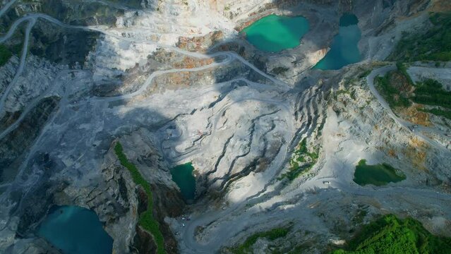 Aerial view flying over a quarry in the tropical, worker and many excavators are working. quarry industry. industrial concept. aerial drones footage. 4K
