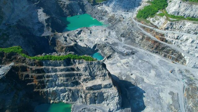 Aerial view flying over a quarry in the tropical, worker and many excavators are working. quarry industry. industrial concept. aerial drones footage. 4K
