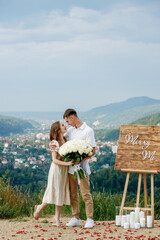 Happy young couple after making a proposal against the background of a mountain landscape. She said...